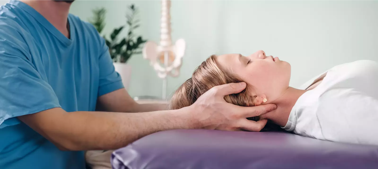 woman lying down with doctor's hands on her head