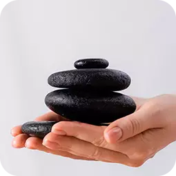 hands holding pile of massage stones